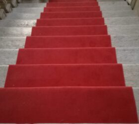 Passatoia in velluto rosso. (Fornitura e posa, con fissaggio di aste e occhioli in ottone)